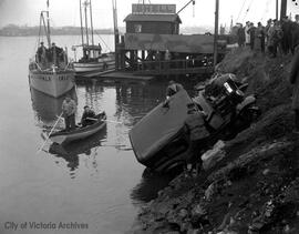 Police investigation and removal of a car in the water off Songhees Road