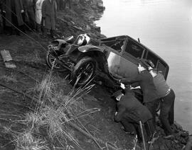 Police investigation and removal of a car in the water off Songhees Road