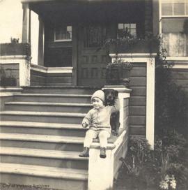 Pat Rochfort on front steps (of family home on Runnymede Ave?) with dog