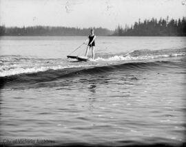 Woman being pulled on board behind a boat