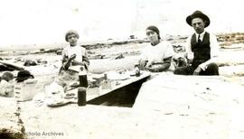 Family having a picnic on the beach (possibly members of the McConnell family)